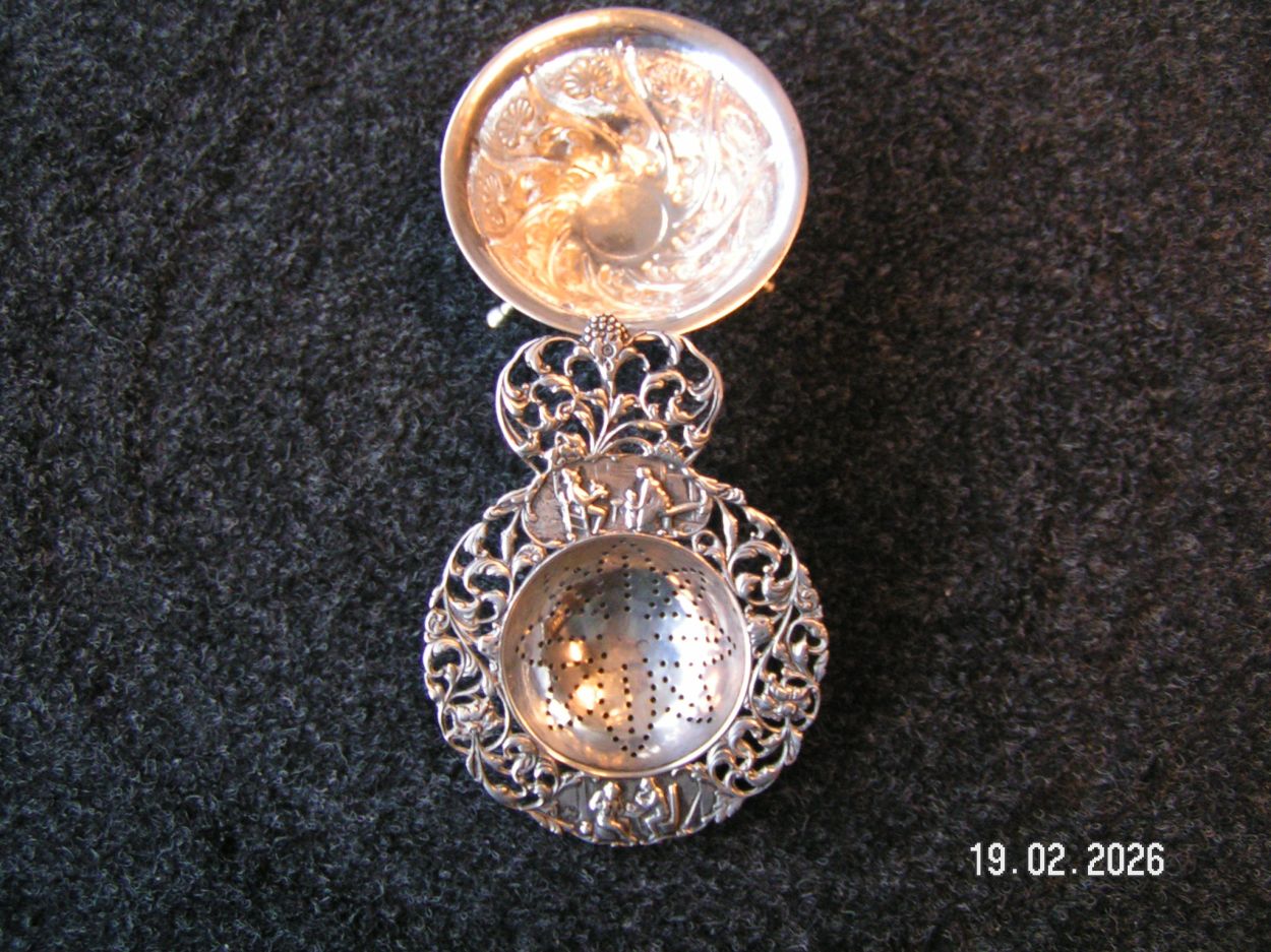 artikelnr. 1602083 Antieke Zilveren Thee Zeef, met Ornamenten in Uitmutende Staat en Gemerk Tweede Gehalte. prijs €125,- euro
