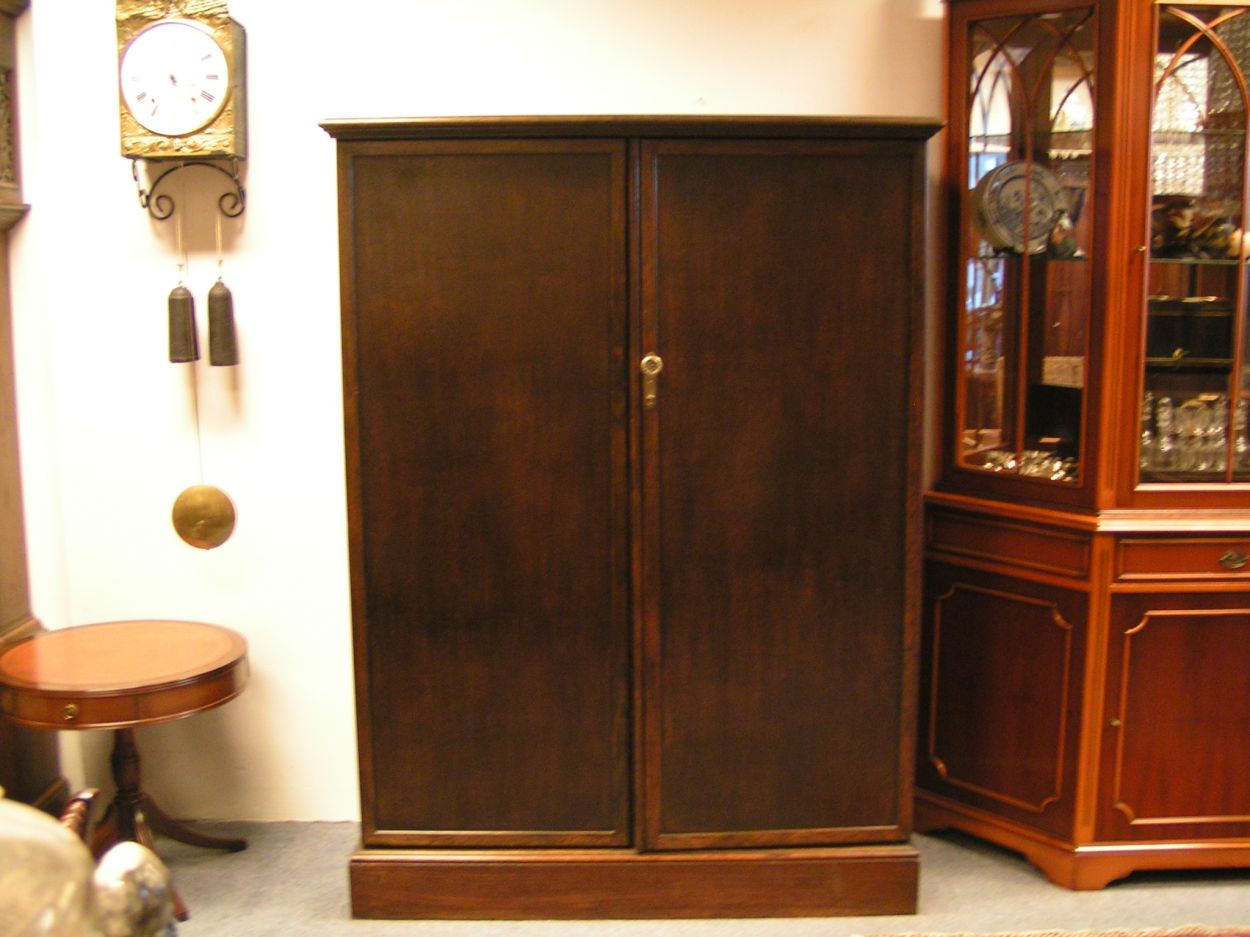 Verkocht 1600240 The Gentlemans Compacton - London:
This piece of furniture is a mystery object. On the outside it looks very ordinary but on the inside it\'s like Aladdin\'s cave.
This Gentleman\'s Compactom resides at Bedervale, a historic home in Braidwood, NSW. The contents of Bedervale is from two families: six generations of the Cogal-Madrel family and the Royds family who moved here in 1973. All the contents that were owned by the Cogal-Madrel family are now owned by the National Trust, gifted by a grant from the National Estate. Bedervale is a living museum.
Victoria, accompanied by her mother Margaret Royds, took me on a tour of the house, sharing with me a few secrets of various objects at Bedervale.
The first object is a Gentleman\'s Compactom.
The Compactom wardrobe - also known as chiffarobe, chifferobe, wardrobe, armoire, dresserobe, closet and Gentleman\'s Butler - demonstrates how an object reflects upon the society that used it. Produced from the 1920s to the 1950s it illustrates how \'designers used wardrobe space to offer the supposed benefits of a tidy and orderly life in a period of rapid change\'. The wardrobe identifies a number of issues including concerns about efficiency, loss of domestic staff, clothes maintenance and middle-class identity\'. Viewed within the context of Bedervale you can see how apparent this was.
During the 1920s Compactoms were often acquired into the marriage when newlyweds started a home together. They were commonly sold as sets with the rest of the bedroom furniture, but could also be purchased individually.
Description:
The moulded cornice above a pair of panelled doors enclosing a well-fitted interior of hooks to the right and shelves and compartments to the left, some with glazed doors and others open, bearing labels reading \'Opera Hats\', \'Pyjamas\' and \'Dress Shirts\' etc., the doors with rails and further shelves, with a lidded compartment for \'Sundries\' in the plinth, 127cm wide x 56cm deep x 174cm high, (50\" wide x 22\" deep x 68.5\" high)
A gentleman\'s mahogany Compactom wardrobe, early 20th Century bearing label to interior reading \'Compactum...41 - 44 Upper Berkely St. London\' and retailer\'s label for \'Finnigans Ltd.\'
Keywords: The Gentlemans Compacton