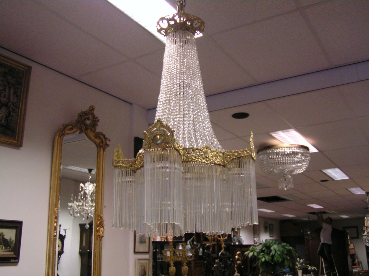 Verkocht artikelnr. 1502a Verguld Bronzen Kroonluchter in Nieuwstaat.
Majesteuze Kroonluchter versierd met cartouches en florale motieven, geregen kristallen kralen en glazen staafjes, h. 85cm
Keywords: Verguld Bronzen KroonLuchter in Nieuwstaat